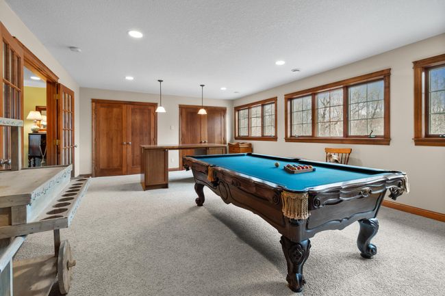 Upper-level billiard / craft room showing French doors, storage closets. Pool table included. Windows overlooking back yard, woods and private horse paddock. | Image 31