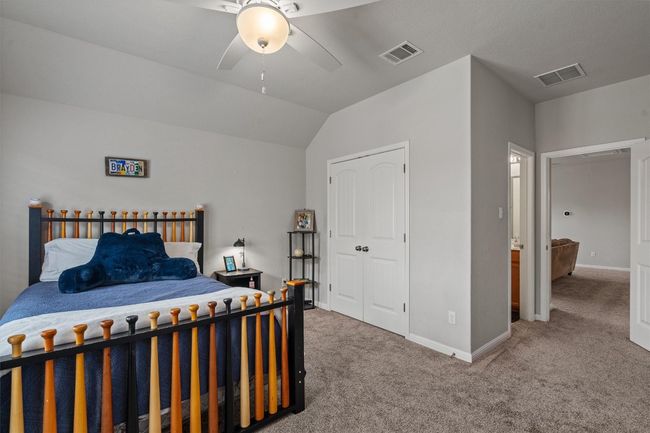 Carpeted bedroom featuring baseboards, vaulted ceiling, and ceiling fan | Image 26