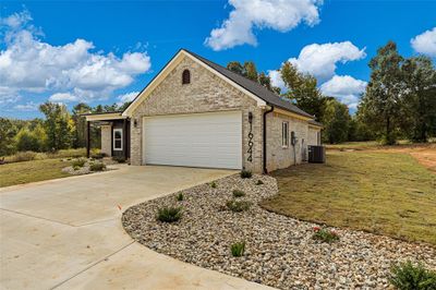 View of front of property featuring central air condition unit, a garage, and a front lawn | Image 3