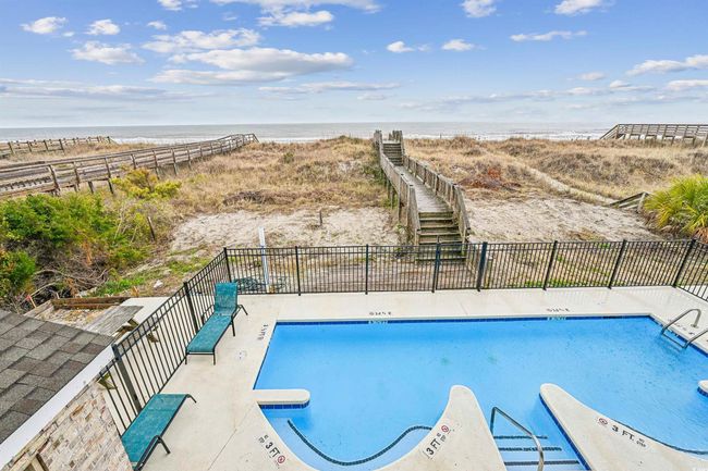 Community pool with view of water and beach | Image 35