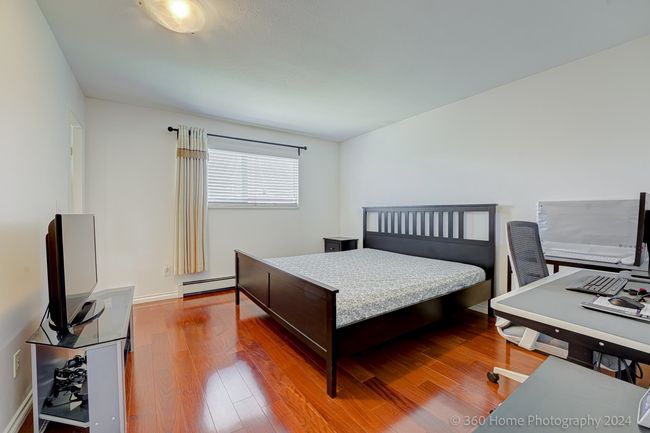 Bedroom featuring baseboards, wood finished floors, and a baseboard radiator | Image 8