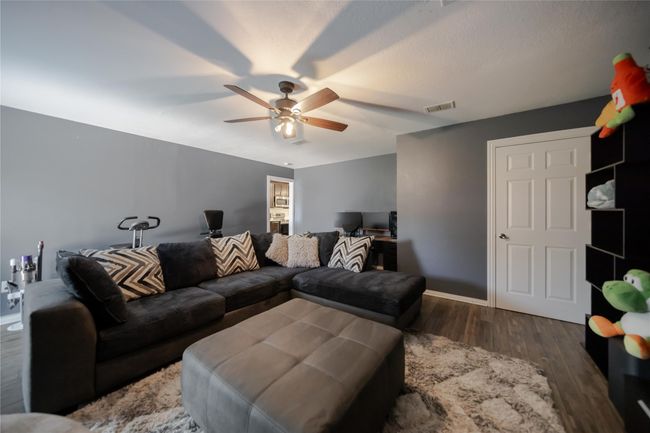 Living area featuring a ceiling fan and wood finished floors | Image 15