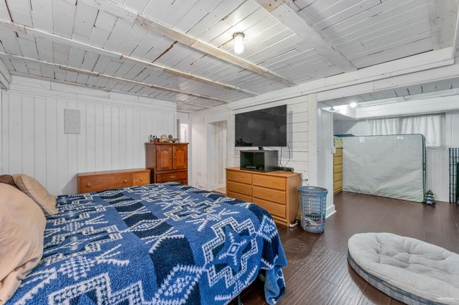 Bedroom featuring hardwood / wood-style floors, wood walls, and beamed ceiling | Image 27