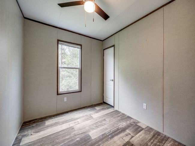 Unfurnished room featuring wood finished floors, ceiling fan, and ornamental molding | Image 13