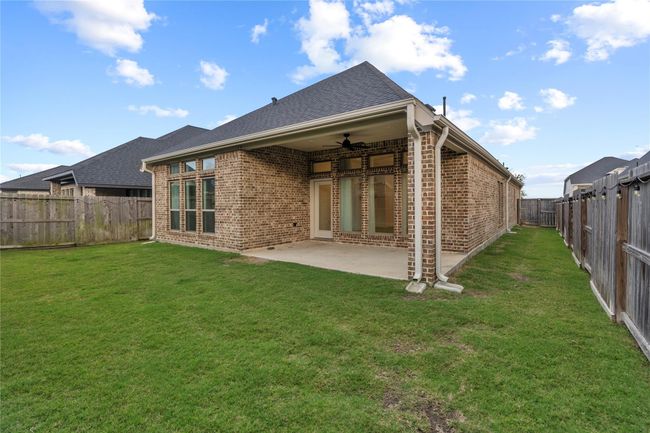 A spacious backyard with covered patio is ideal for outdoor activities. | Image 26