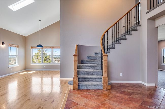 Stairway with wood finished floors, high vaulted ceiling, and baseboards | Image 7