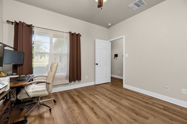 Office area with visible vents, baseboards, a ceiling fan, and wood finished floors | Image 17