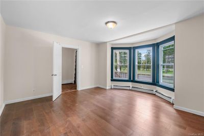 Empty room featuring a baseboard radiator and dark hardwood / wood-style floors | Image 2