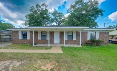 Ranch-style home with covered porch and a front yard | Image 1