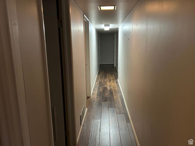 Hall featuring dark wood finished floors and baseboards | Image 9