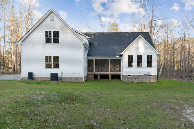 Rear view of property featuring crawl space, a lawn, central AC, and a sunroom | Image 45