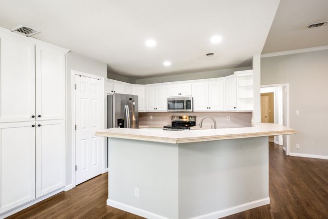 Kitchen with stainless steel appliances, dark wood-style flooring, open shelves, white cabinetry, and recessed lighting | Image 10