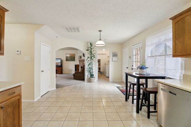 Dining room with arched walkways, a textured ceiling, visible vents, and light tile patterned floors | Image 11