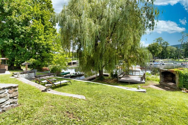 View of grassy yard with a water view and a boat dock | Image 11