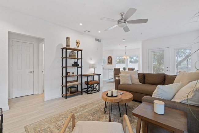 Living room (half bath and hall closet on left) with ambient natural lighting and beautiful floors throughout. | Image 6