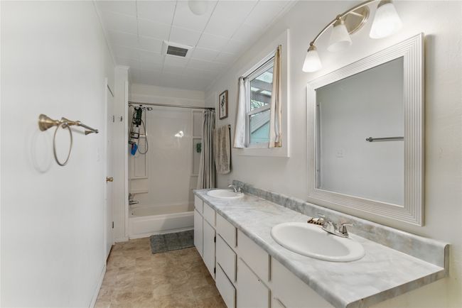 Full bathroom with shower / bath combo, a sink, visible vents, and double vanity | Image 18