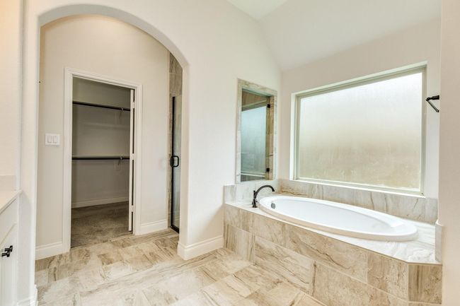 The primary has a glass-enclosed walk-in shower and a soaking tub. | Image 33