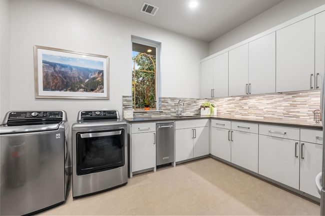 Clothes washing area featuring laundry area, separate washer and dryer, a sink, and visible vents | Image 22