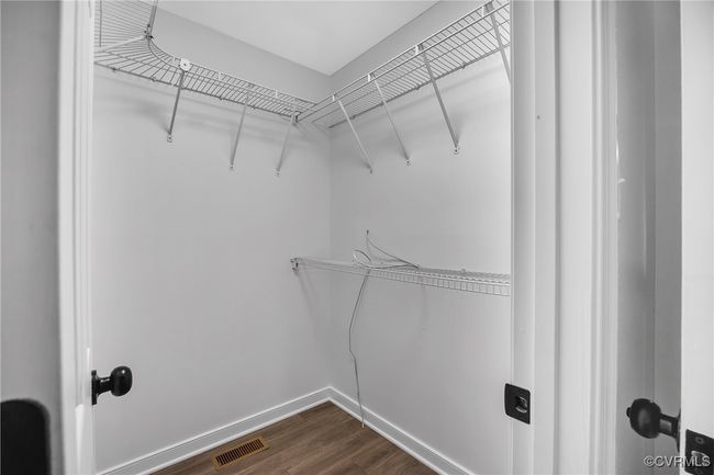 Spacious closet with dark wood-style flooring | Image 15