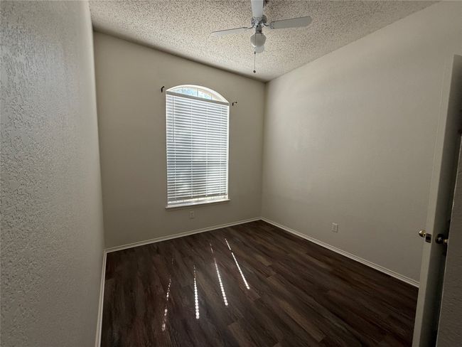 Unfurnished room featuring a textured ceiling, dark wood-style flooring, ceiling fan, and baseboards | Image 18