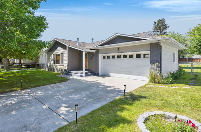 Single story home featuring concrete driveway, an attached garage, and brick siding | Image 44