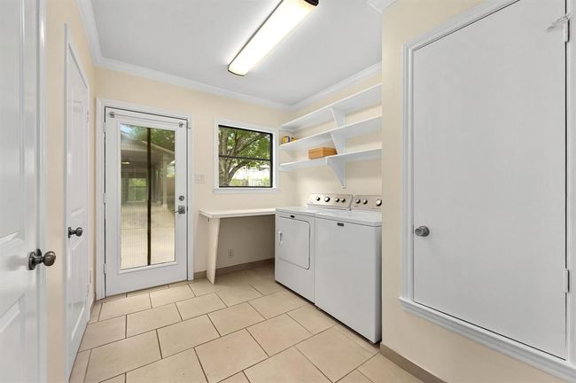 Washroom featuring washer and dryer, crown molding, and light tile patterned floors | Image 12