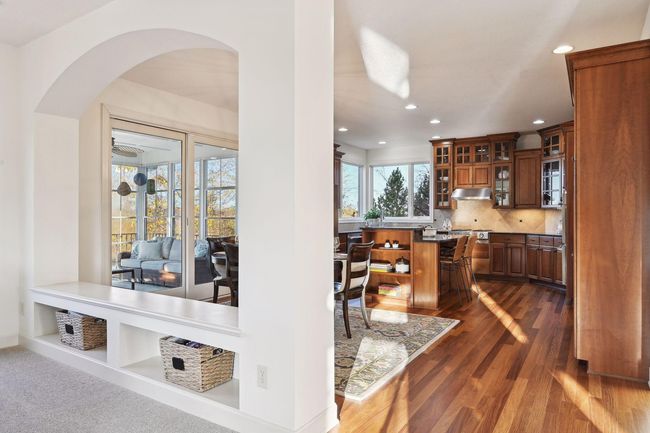 Bench separating the family room from the kitchen has a convenient space to house games or blankets | Image 18