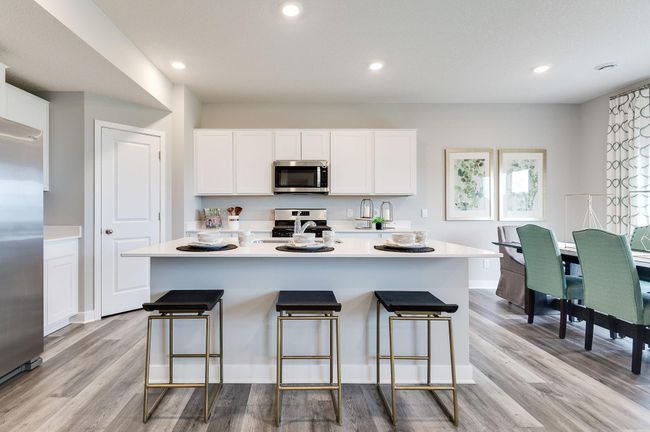 A stunning kitchen layout, all while remaining remarkably functional: The quartz is endless, the sink is under-mounted, the range is gas, the micro-hood is vented to the exterior of the home! Photo of model home, color & options may vary. | Image 9