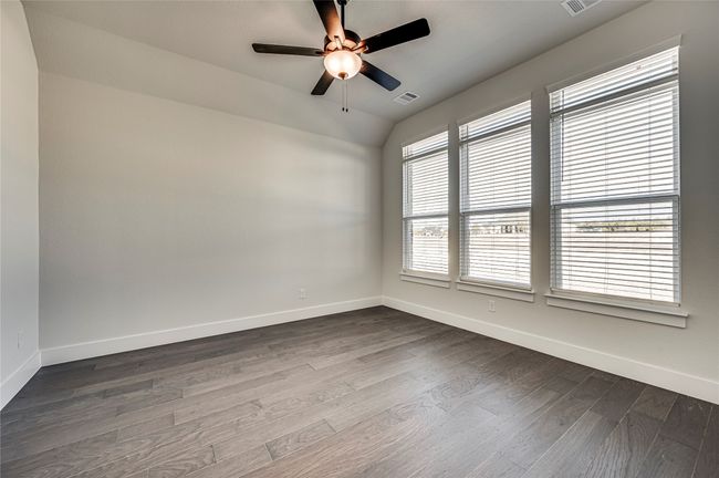 Spare room with dark wood-type flooring, visible vents, baseboards, and ceiling fan | Image 18
