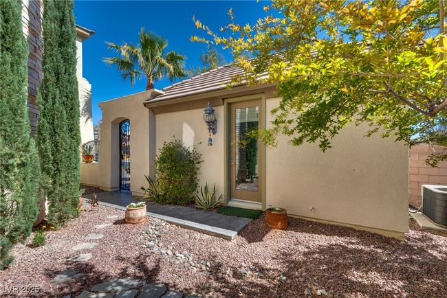 View of front of property with cooling unit, a tile roof, stucco siding, and a gate | Image 9