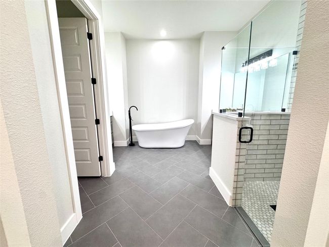 Full bathroom featuring a shower stall, a soaking tub, tile patterned floors, recessed lighting, and a textured wall | Image 20