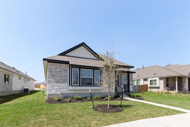 Bungalow-style home with a shingled roof, central air condition unit, a front yard, and stone siding | Image 33