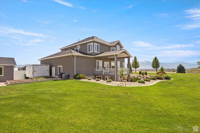 Rear view of property with a yard, stucco siding, cooling unit, and a mountain view | Image 47