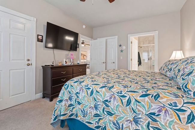 Bedroom featuring light carpet, connected bathroom, and ceiling fan | Image 6