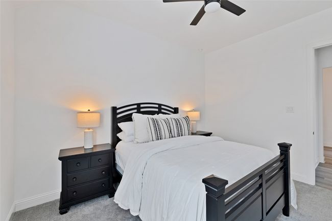 Bedroom with baseboards, light carpet, and a ceiling fan | Image 7
