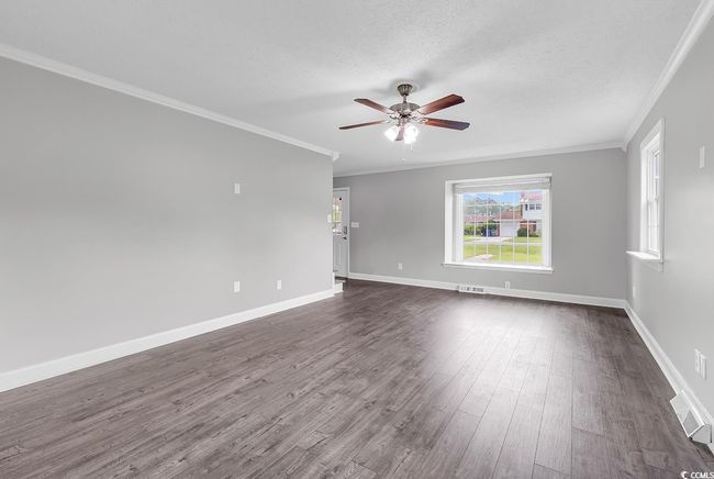Unfurnished room featuring crown molding, ceiling fan, dark wood finished floors, and a textured ceiling | Image 6