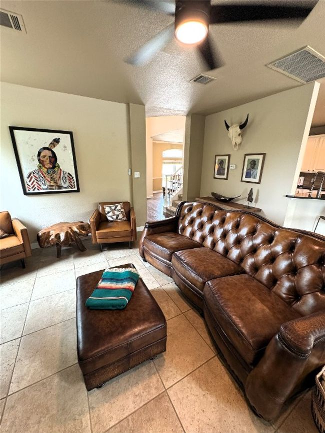Living room with ceiling fan and a textured ceiling. | Image 7