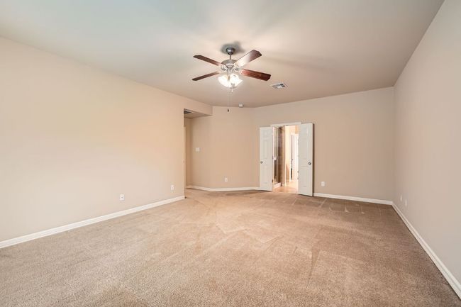 Empty room with a ceiling fan and light colored carpet | Image 17