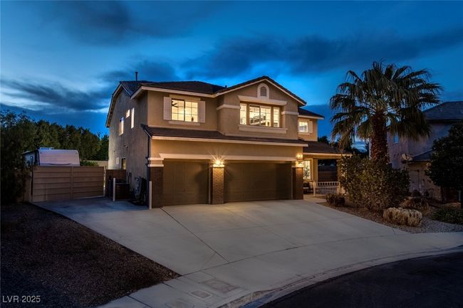 Traditional-style home with a garage, concrete driveway, stucco siding, and fence | Image 47