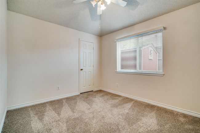 Carpeted empty room featuring a textured ceiling and a ceiling fan | Image 19