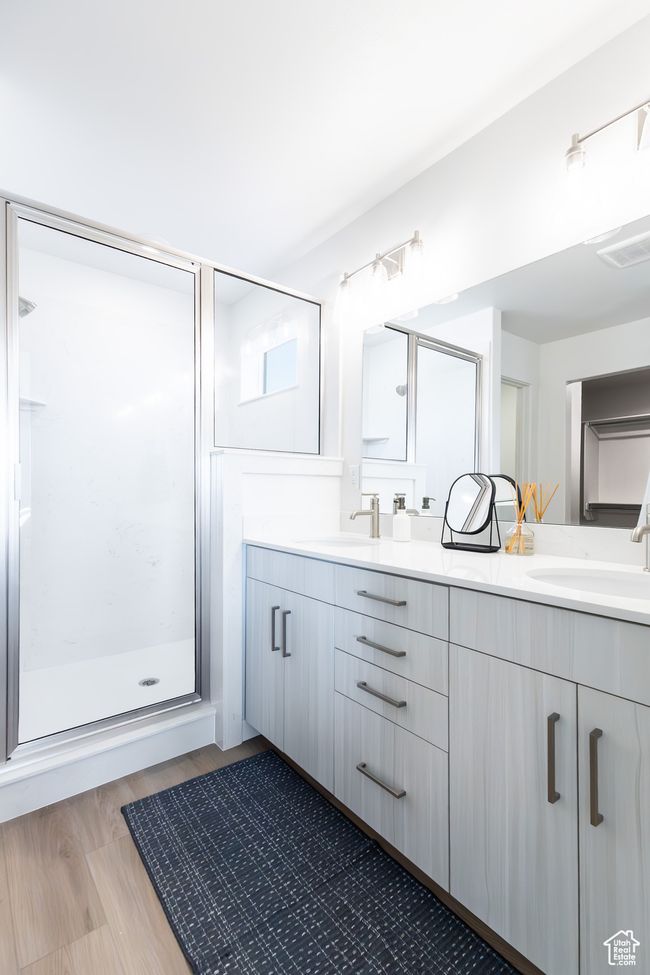 Full bathroom featuring double vanity, a shower stall, and wood finished floors | Image 21