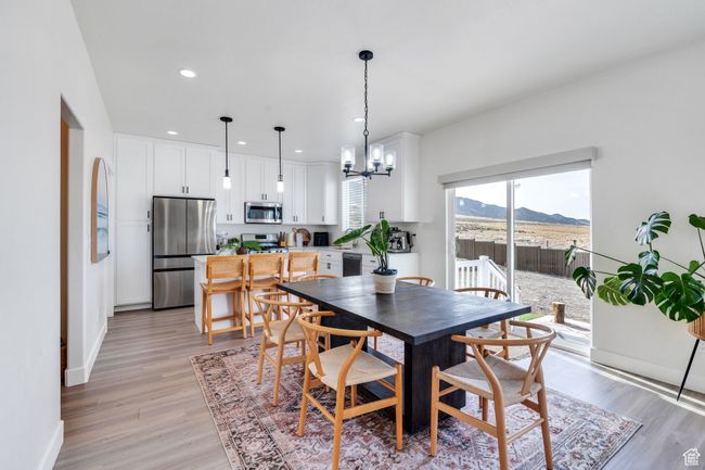 Dining space featuring baseboards, a mountain view, a chandelier, recessed lighting, and light wood-style flooring | Image 9