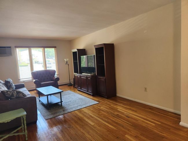 Living area with hardwood / wood-style floors and a wall mounted air conditioner | Image 12