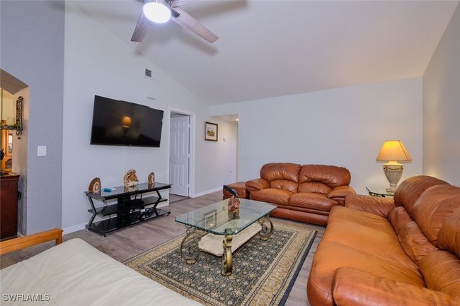 Living area with lofted ceiling, wood finished floors, and ceiling fan | Image 5
