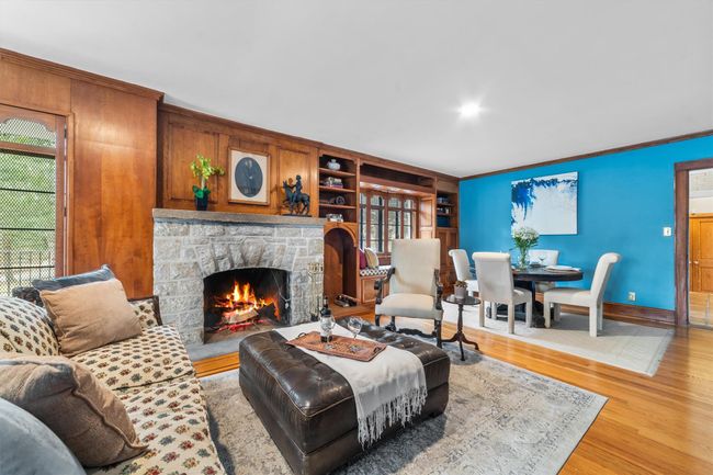 Living room, built in features, ornamental molding, a fireplace, and wood finished floors | Image 6