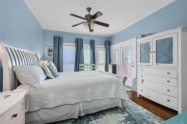 Bedroom featuring access to exterior, dark wood-style floors, crown molding, and ceiling fan | Image 23