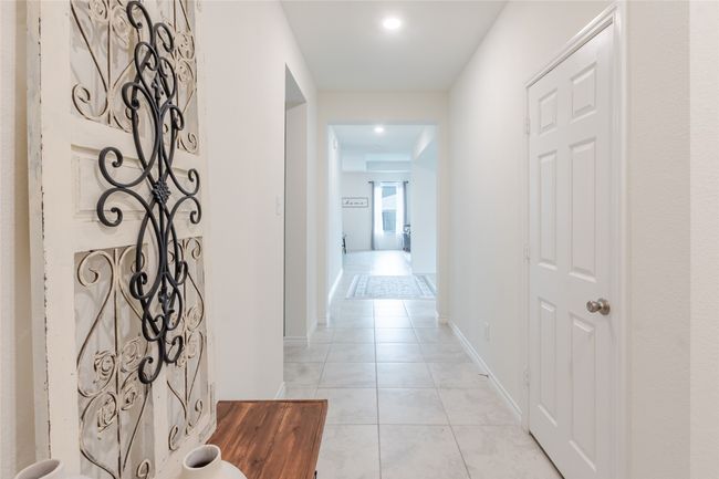Hall featuring light tile patterned flooring and baseboards | Image 7
