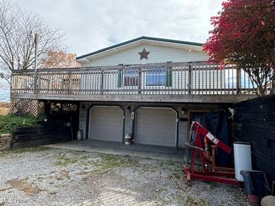 Garage side of home with oversized wrap-around deck. | Image 2