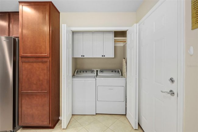 Convenient laundry closet located just off the kitchen near the garage—easy access for daily living. | Image 6