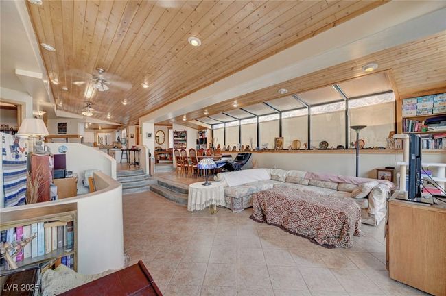 Living area with tile patterned flooring, wood ceiling, vaulted ceiling, ceiling fan, and recessed lighting | Image 12